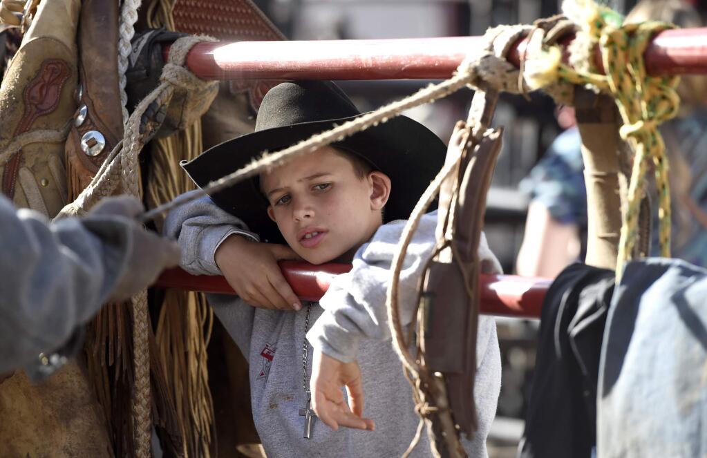 Gavin Matthews watches as ropes are prepared for the bull riding exhibition at the premiere of 'The Longest Ride' at the TCL Chinese Theatre on Monday, April 6, 2015, in Los Angeles. (Photo by Chris Pizzello/Invision/AP)