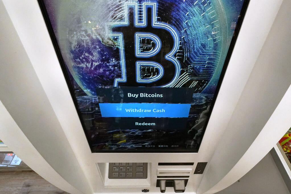 FILE - The Bitcoin logo appears on the display screen of a cryptocurrency ATM in Salem, N.H., Feb. 9, 2021. (AP Photo/Charles Krupa, File)