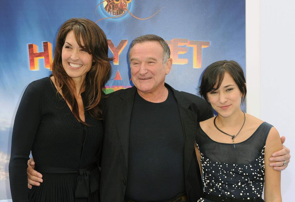 FILE - In this Nov. 13, 2011 file photo, Susan Schneider, from left, Robin Williams, and Zelda Williams arrive at the premiere of 'Happy Feet Two' at Grauman's Chinese Theater, in Los Angeles. Attorneys for Robin Williamsí wife and children are headed to court in their battle over the late comedianís estate. The attorneys are scheduled to appear before a San Francisco probate judge on Monday, as they argue over who should get clothes and other personal items the actor kept at one his Northern California homes. In papers filed in December, Williams' wife, Susan, says some of the late actor's personal items were taken without her permission. She has asked the court to set aside the contents of the home she shared with Williams from the jewelry, memorabilia and other items Williams said the children should have. (AP Photo/Katy Winn, File)