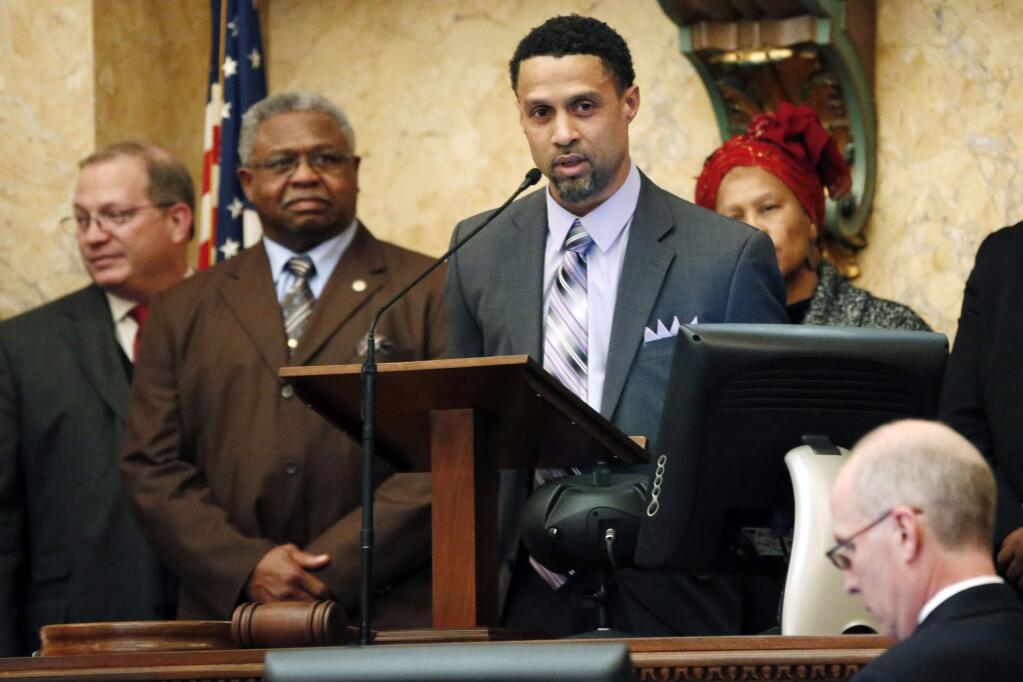 Reps. Jeffrey Guice, R-Ocean Springs, left, and Billy Broomfield, D-Moss Point, second from left, listen as former basketball player Mahmoud Abdul-Rauf expresses his thanks for being honored by the Mississippi House with a resolution noting his athletic endeavors, Tuesday, Feb. 26, 2013, at the Capitol in Jackson, Miss. Abdul-Rauf played for the Denver Nuggets, Sacramento Kings and Vancouver Grizzlies. (AP Photo/Rogelio V. Solis)