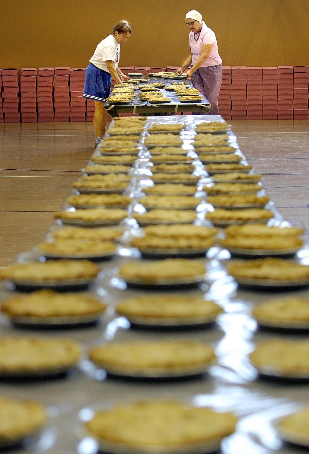 Bobbie Johanson, left, and Marian McDonald arrange some of the 1,500 cooling apple pies on Friday at the Community Church of Sebastopol.