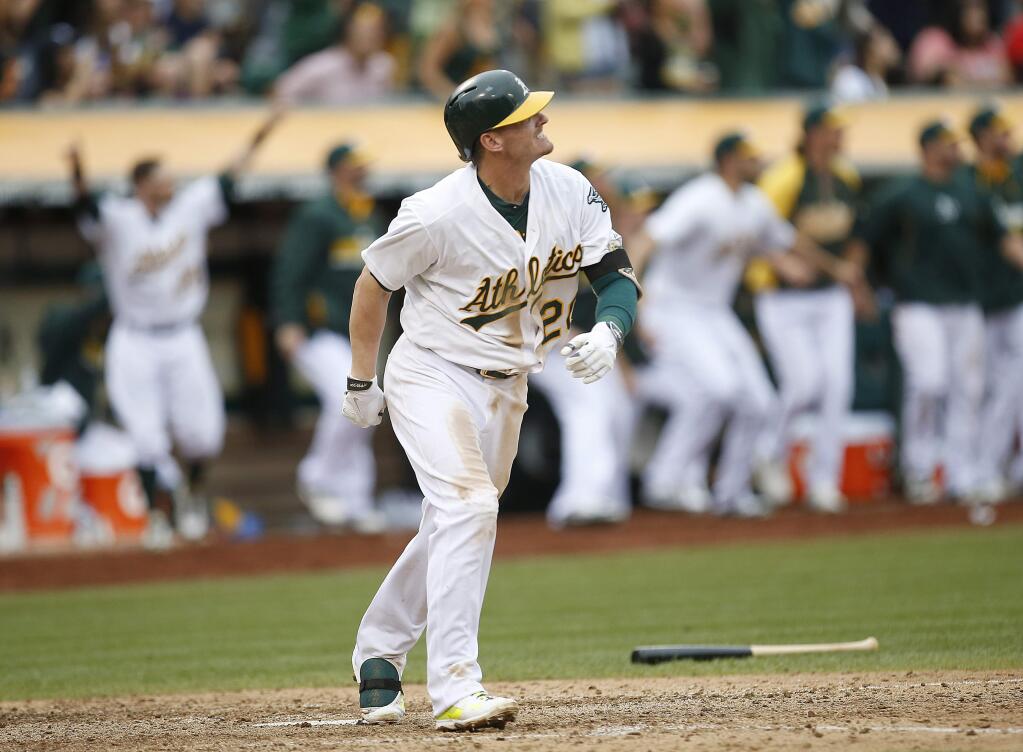 Oakland Athletics' Josh Donaldson watches his two-run home run against the Philadelphia Phillies in the 10th inning of a baseball game Sunday, Sept. 21, 2014, in Oakland, Calif. Oakland won 8-6. (AP Photo/Tony Avelar)