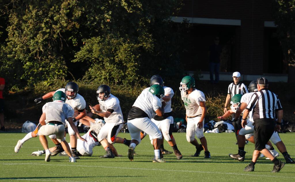 Varsity squads from Sonoma Valley (green helmets) and Santa Rosa High (black helmets) mix it up at Santa Rosa Junior High on Friday, Aug. 16, in a multi-squad scrimmage as both teams prepare for the Fall 0219 high school football season. (Christian Kallen/Index-Tribune)