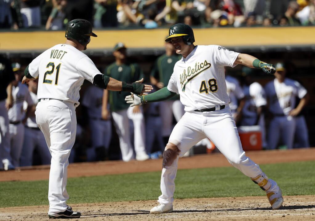 Oakland Athletics' Ryon Healy (48) is met at the plate by teammate Stephen Vogt (21) following Healy's two-run home run against the Texas Rangers during the second inning of a baseball game, Sunday, Sept. 25, 2016, in Oakland, Calif. (AP Photo/Marcio Jose Sanchez)