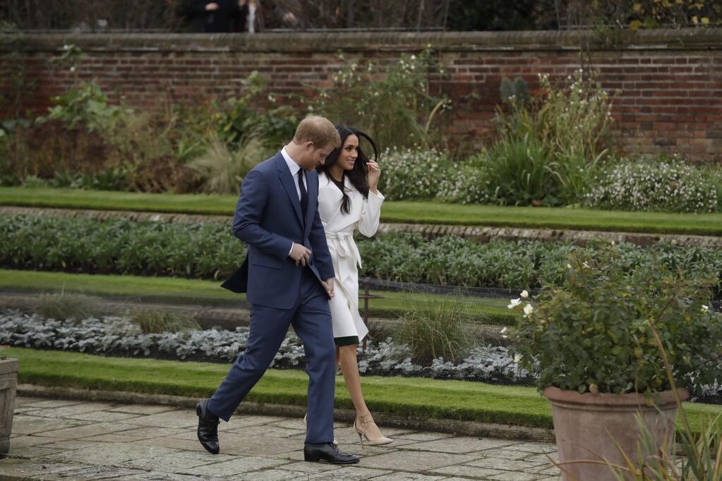 FILE - In this Nov. 27, 2017, file photo, Britain's Prince Harry and his fiancee Meghan Markle pose for photographers during a photocall in the grounds of Kensington Palace. (AP Photo/Matt Dunham, File)