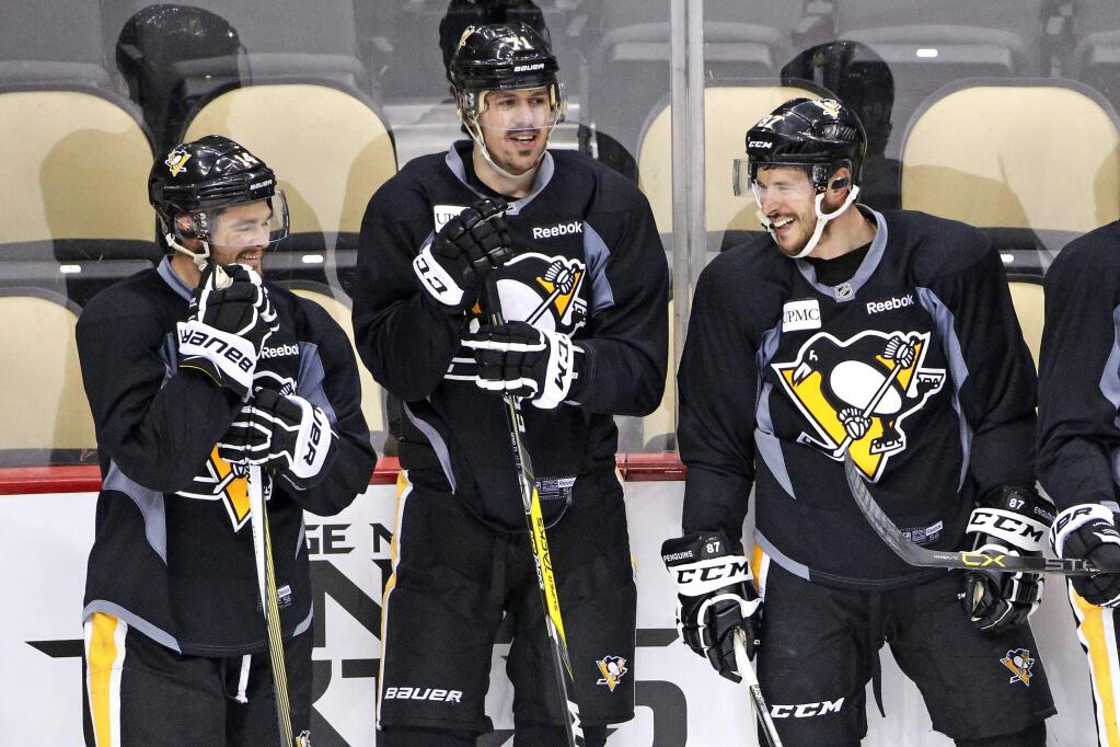 Pittsburgh Penguins' Chris Kunitz, left, Evgeni Malkin (71) and Sidney Crosby (87) wait to run a drill during hockey practice at the Consol Energy Center in Pittsburgh, Sunday May 29, 2016. The Penguins are preparing for Game 1 of the Stanley Cup finals against the San Jose Sharks on Monday, May 30, in Pittsburgh. (AP Photo/Gene J. Puskar)