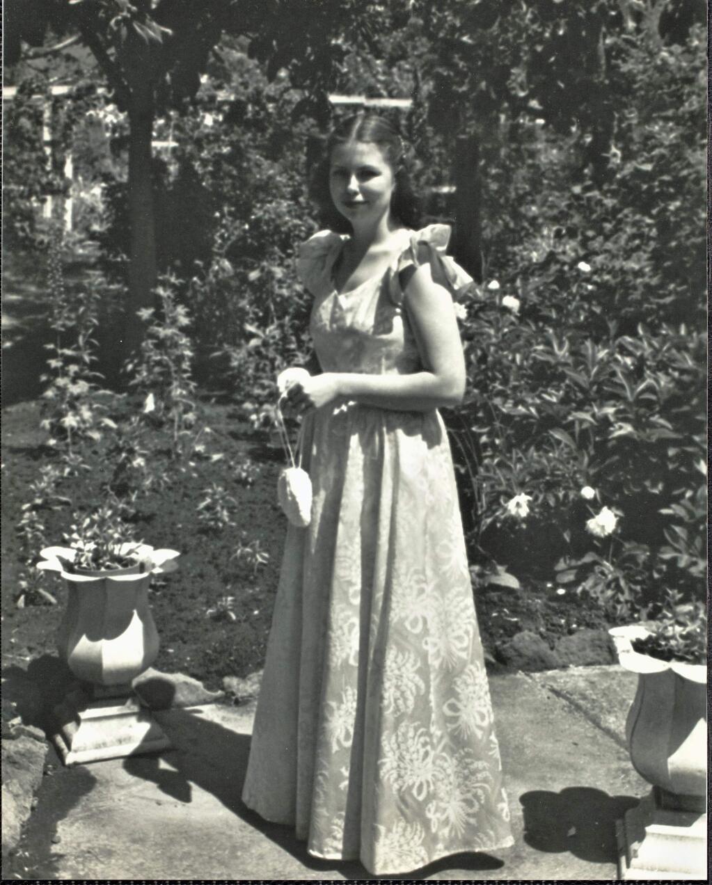 An unidentified girl poses in a garden wearing a long dress for a formal dance in 1946. (Courtesy of the Sonoma County Library)