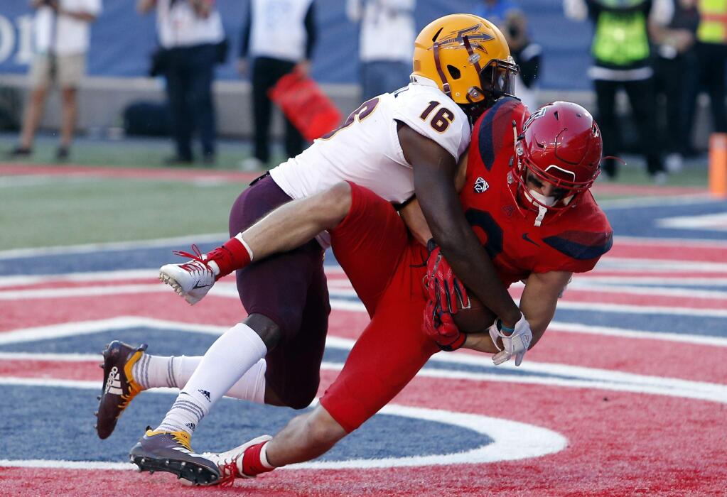 Arizona wide receiver Tony Ellison, right, holds onto the football after getting hit by Arizona State safety Aashari Crosswell (16) for a touchdown in the second half during an NCAA college football game, Saturday, Nov. 24, 2018, in Tucson, Ariz. (AP Photo/Rick Scuteri)