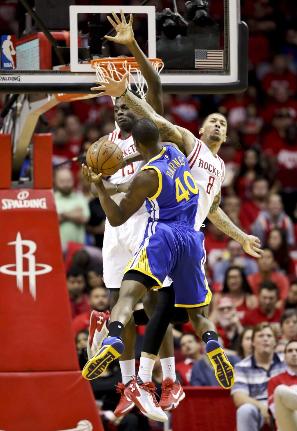 Golden State Warriors forward Harrison Barnes, middle, shoots between Houston Rockets forward Clint Capela, left, and forward Michael Beasley during the second half of Game 3 of a first-round playoff series, Thursday, April 21, 2016, in Houston. (AP Photo/David J. Phillip)