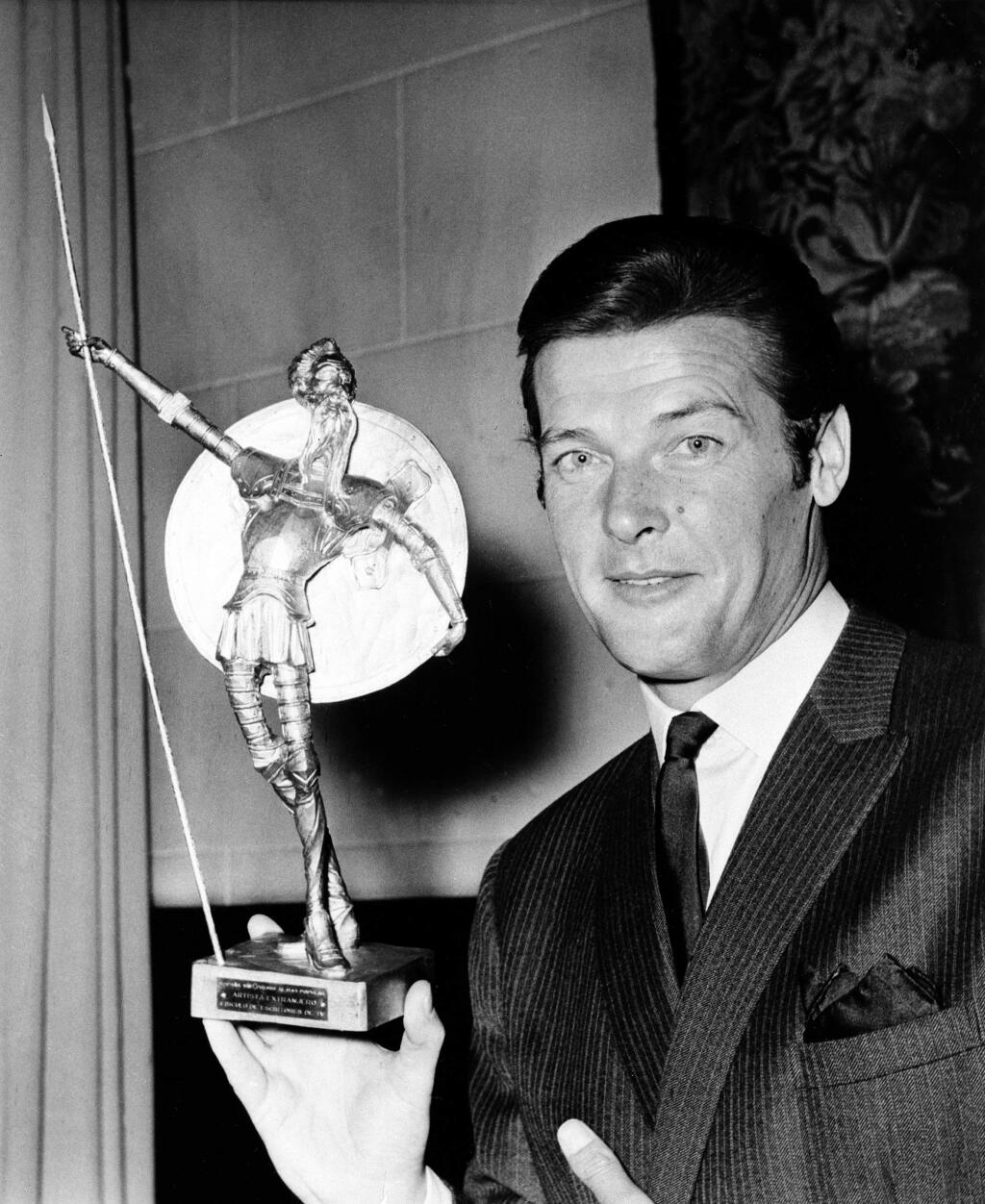 FILE - This is a July 8, 1968 file photo of British actor Roger Moore as he poses with Spain's most prized award, the Don Quixote Award, which was presented to him at the Spanish Embassy in London, The award, an equivalent to Hollywood's Oscar, was awarded to him for his role in the British series 'The Saint,' one of the most popular shows on Spanish TV. Roger Moore's family said Tuesday May 23, 2017 that the former James Bond star has died after a short battle with cancer ?(AP Photo/ File)