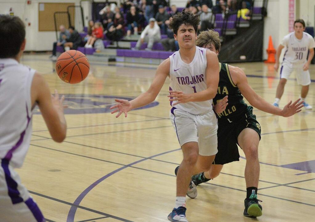 SUMNER F0WLER/FOR THE ARGUS-COURIEREven a crash from behind can't stop Petaluma's Esteban Bermudez from delivering an accurate pass. The Trojans are counting on the junior not only to shoot, but be a ball distributor as well.