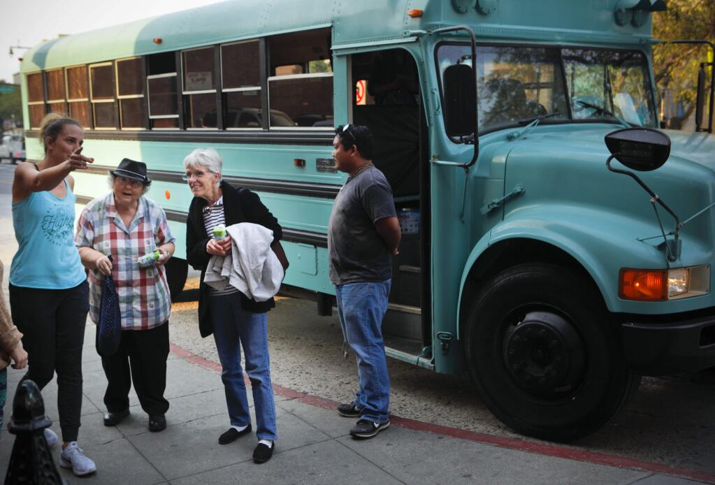 Petaluma, CA, USA. Tuesday, October 10, 2017._ Barbara Flournoy of Santa Rosa (third from left) and her friend, who narrowly escaped the wildfire, took advantage of a bus ride from volunteer, Donnie Penales (far right) who donated the services of his bus to transport evacuees from shelters to downtown restaurants that offered free hot meals. The ladies dined at the Mystic Theatre. (CRISSY PASCUAL/ARGUS-COURIER STAFF)