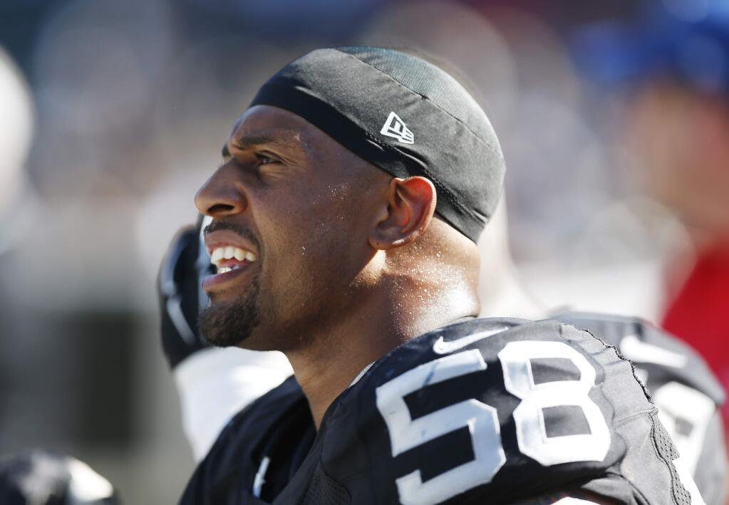 Oakland Raiders defensive end LaMarr Woodley sits on the bench in the fourth quarter of an NFL football game against the Houston Texans Sunday, Sept. 14, 2014, in Oakland. (AP Photo/Beck Diefenbach)