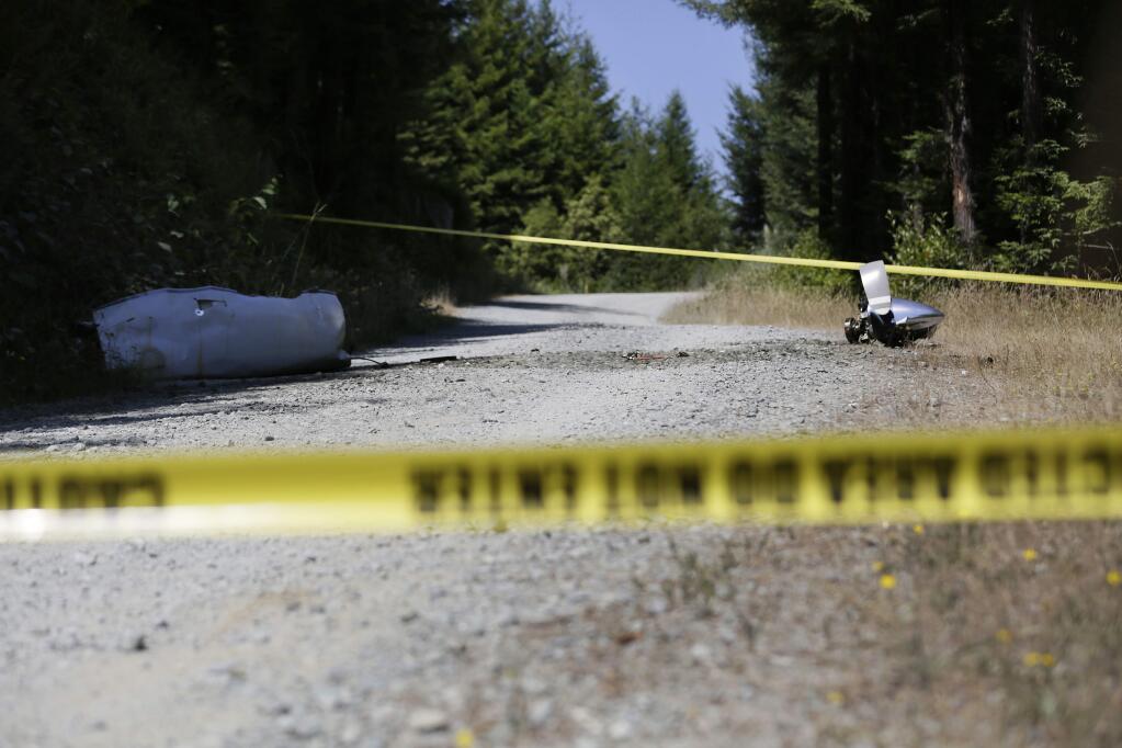 An engine nose cone with a bent propellor blade and other wreckage from a medical transport plane that crashed are shown on a road east of Crannell, Calif., Friday, July 29, 2016. Authorities found the wreckage of a small medical transport plane with four people aboard and confirmed at least two deaths Friday after the pilot reported smoke filling the cockpit and a search started across a densely forested mountain range in Northern California. (Shaun Walker/The Times-Standard via AP)