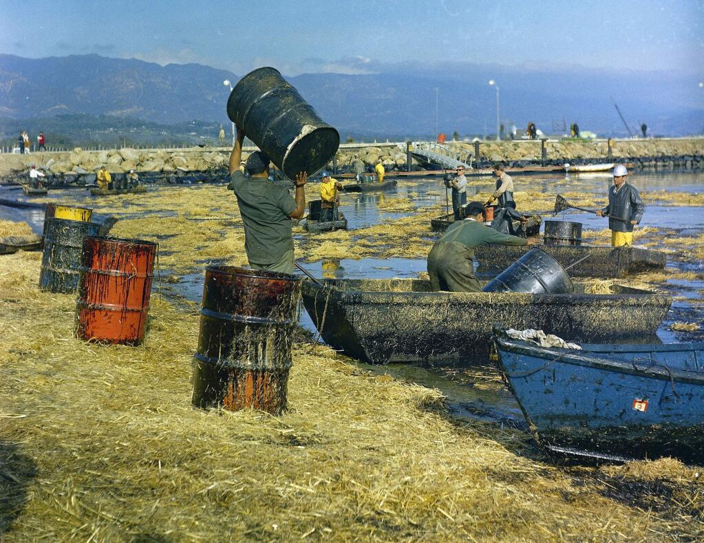 FILE - In this Feb. 7, 1969 file photo, workers collect oil-soaked straw from the beach at Santa Barbara Harbor, Calif., following a leak from an off-shore well that covered area beaches. California commissions that oversee coastal lands and water pushed the Trump administration to leave the state out of plans to expand offshore drilling, warning the state would block the construction of pipelines to get oil back to land. The agencies weighed in ahead of a public meeting Thursday, Feb. 8, 2018, in Sacramento. (AP Photo, FILE)