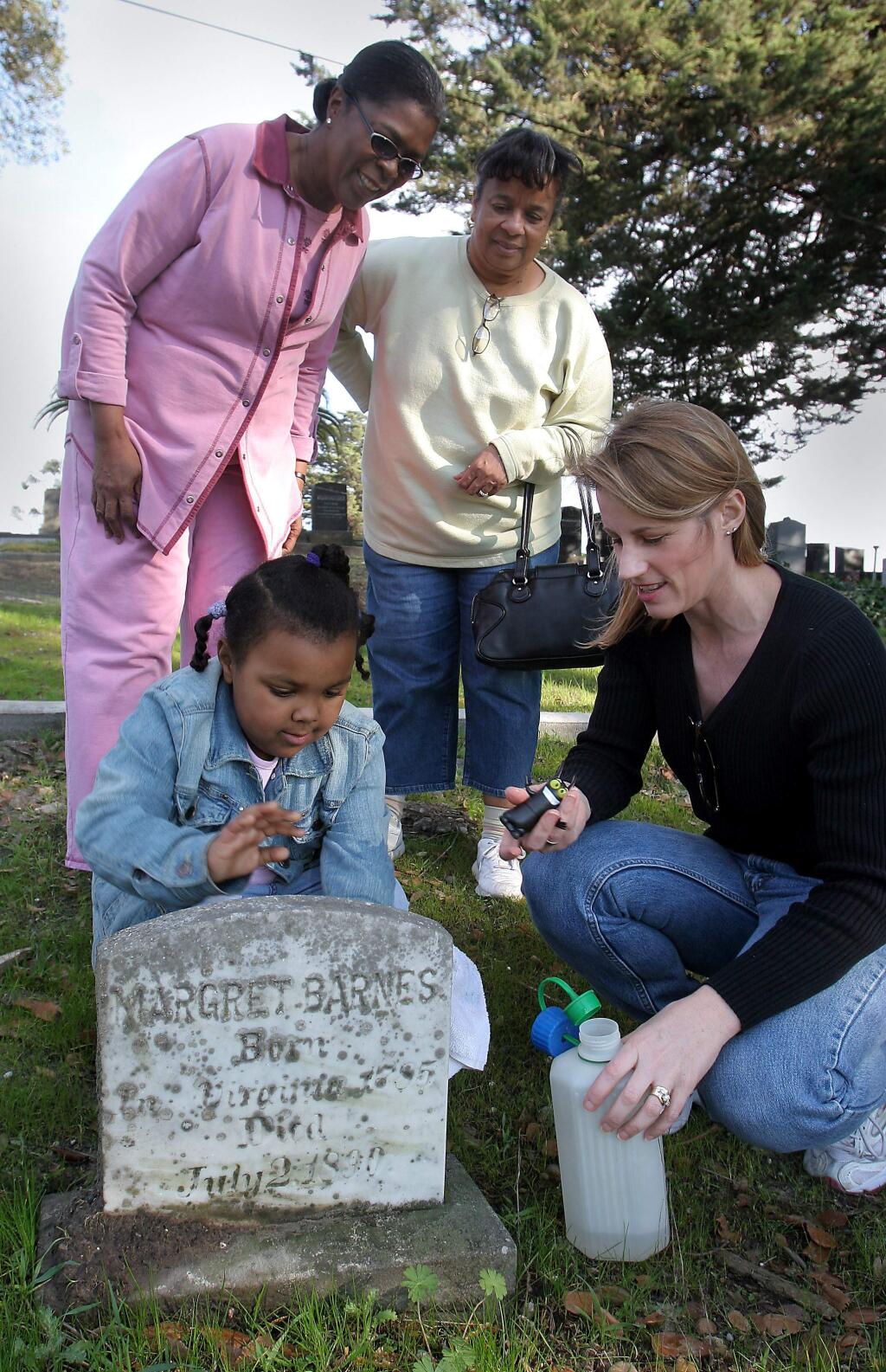Four-year-old Jade Ross cleans off the tombstone of Petaluma pioneer Margret Barnes at the Cypress Hill Memorial Park. Accompanying Jade is Petaluma historian and Sonoma County librarian Katherine Rinehart (kneeling), Jade's grandmother Faith Ross, in pink, and Joann Gleaves. The women were doing research for an exhibit on black pioneers they curated for the Petaluma Museum. (Jeff Kan Lee/ The Press Democrat, 2007)