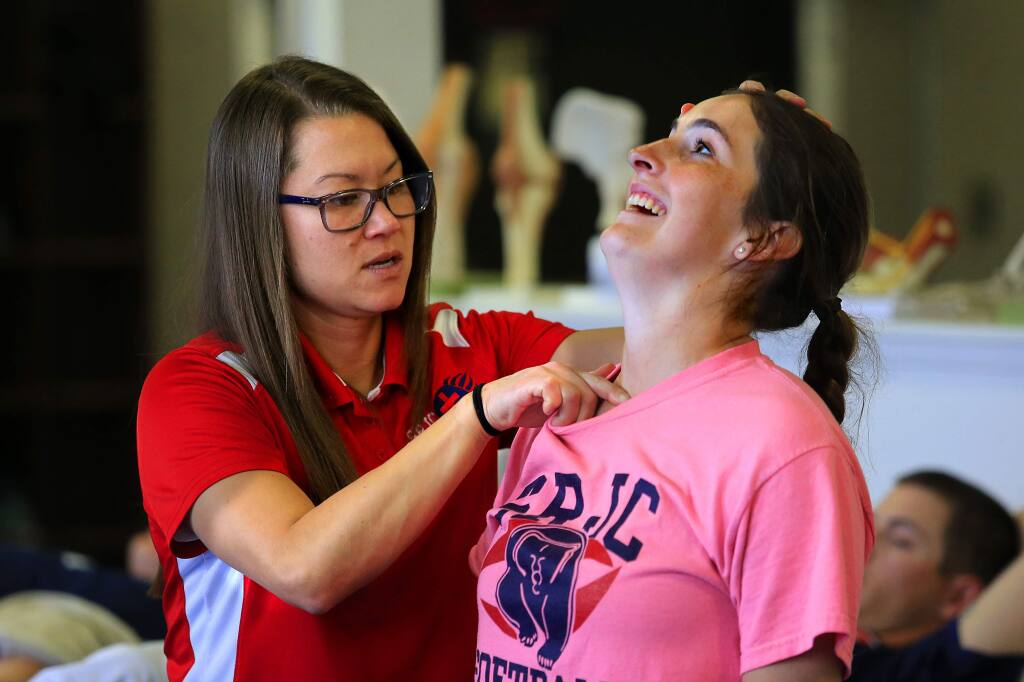 SRJC head athletic trainer Monica Ohkubo works on the shoulder of softball player Cailyn Callison in the Sports Medicine Department. (John Burgess/The Press Democrat)