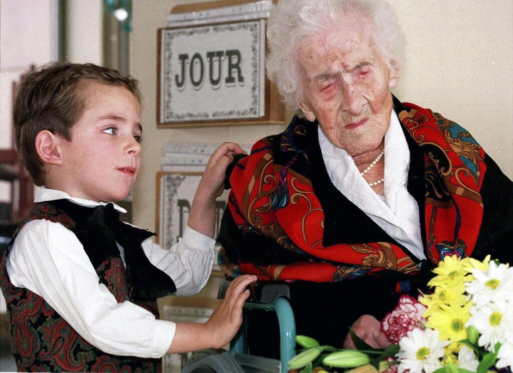 FILE - In this Feb. 12, 1997 file photo shows Thomas, 5, looks at Jeanne Calment after he brought her flowers at her retirement home in Arles, southern France. Calment, believed to be the world's oldest person, died at the age of 122 in 1997. New research published in the journal Nature on Wednesday, Oct. 5, 2016 suggests there's a limit to our life span and that the odds of breaking Calment's record are small. (AP Photo/Florian Launette,File)