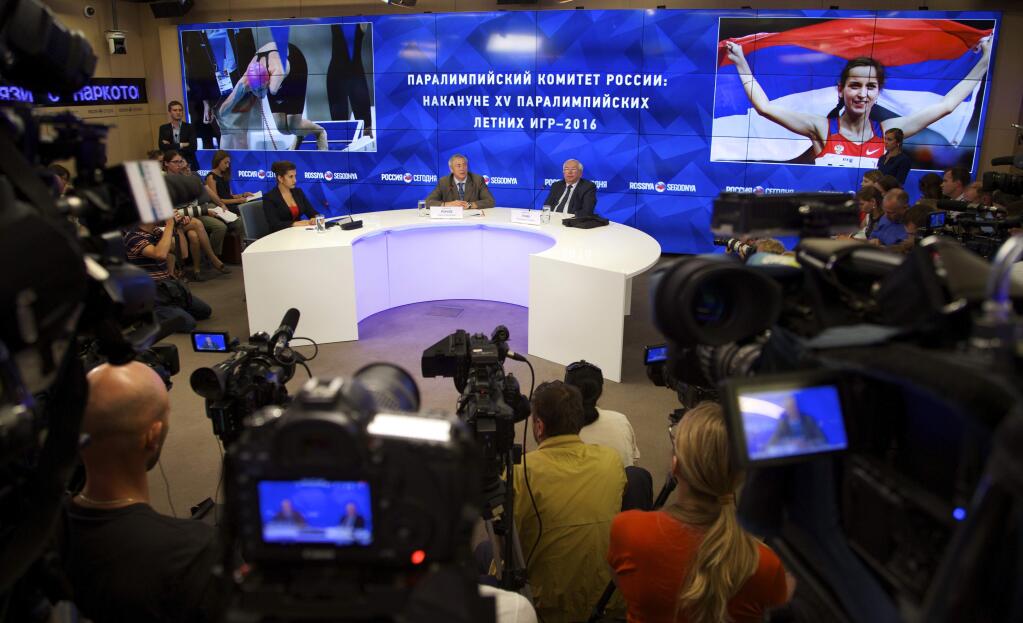FILE - A Monday, Aug. 8, 2016 photo from files showing the President of the Russian Paralympic Committee Vladimir Lukin, background centre right, during a news conference in Moscow. The Court of Arbitration for Sport (CAS) has confirmed Russia's ban from the Paralympic Games as punishment for a state-backed doping program. CAS announced its urgent verdict Tuesday, Aug. 23, 2016 in Rio de Janeiro, to dismiss the Russian Paralympic Committee's appeal against exclusion from the Sept. 7-18 games in Rio de Janeiro. (AP Photo/Ivan Sekretarev, File)