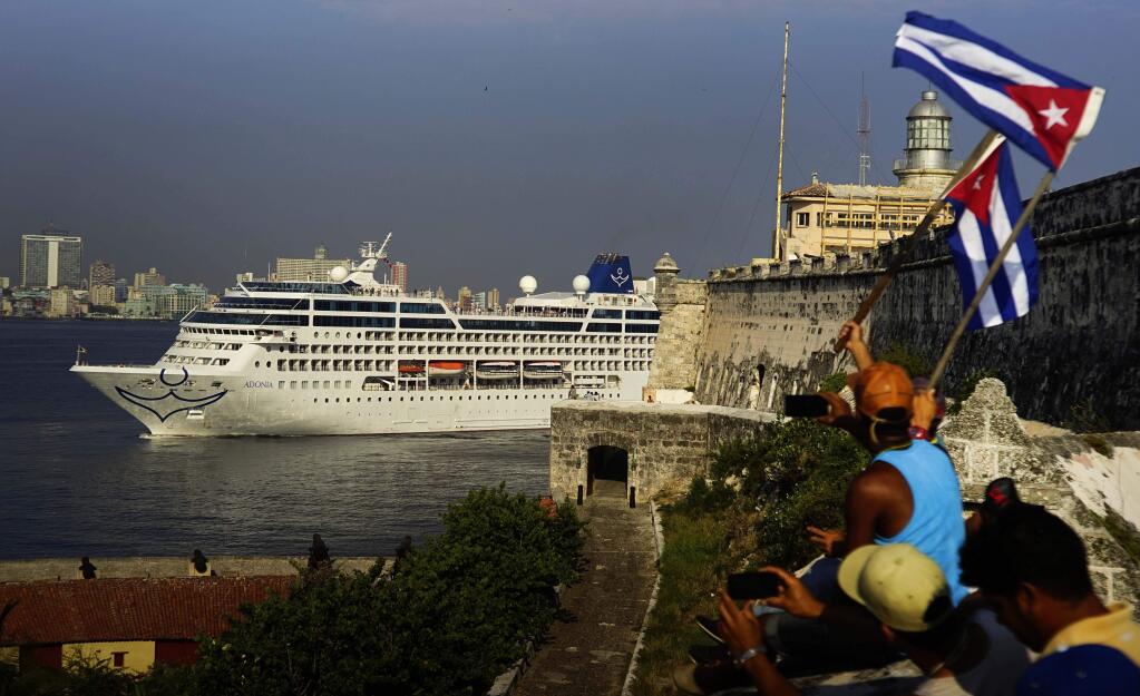 People waving Cuban flags greet passengers on Carnival's Adonia cruise ship as they arrive from Miami in Havana on Monday. (RAMON ESPINOSA / Associated Press)