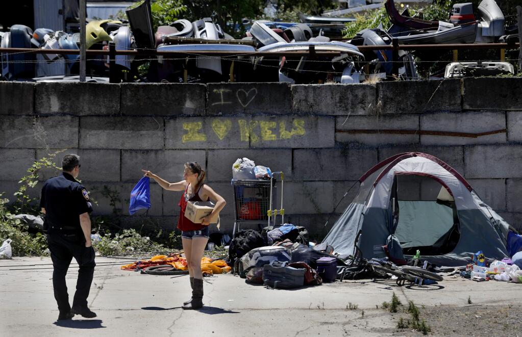 Homeless woman Merry Potter talks with Santa Rosa Police Sgt. Jonathan Wolf as police evict more than two dozen homeless people from a camp off the Joe Rodota Trail near Roberts Ave in Santa Rosa on Thursday, June 21, 2018. (Beth Schlanker/ The Press Democrat)