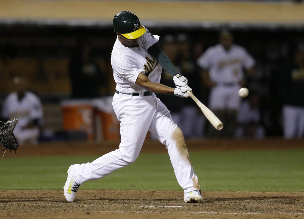 Oakland Athletics' Marcus Semien swings for a two run triple hit off Milwaukee Brewers' Blaine Boyer in the seventh inning of a baseball game Tuesday, June 21, 2016, in Oakland, Calif. (AP Photo/Ben Margot)