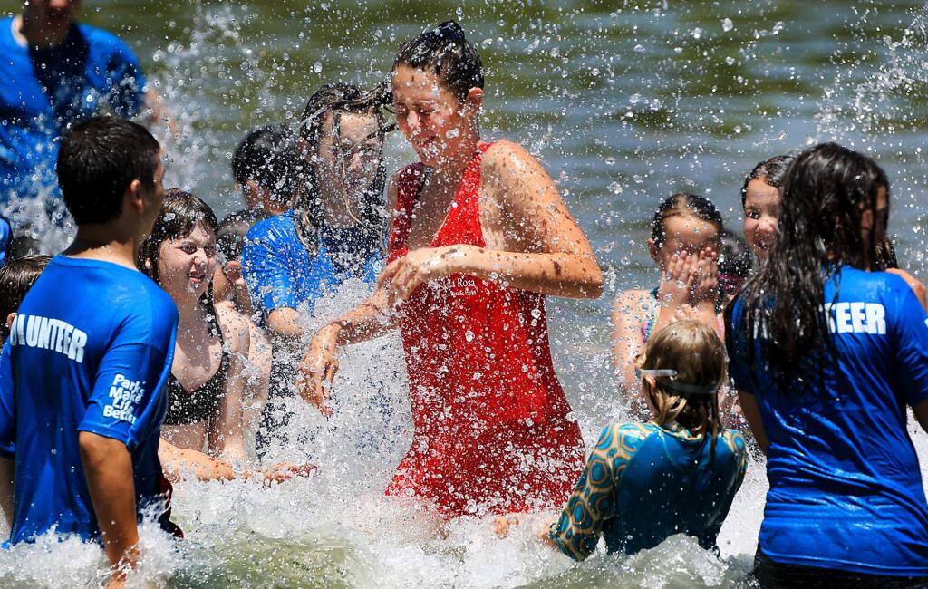 Camp Wa-Tam counselor Evi 'Turtle' Burke splashes with campers in the swimming lagoon at Spring Lake Regional Park in Santa Rosa on Tuesday, June 13, 2017. (KENT PORTER/ PD)