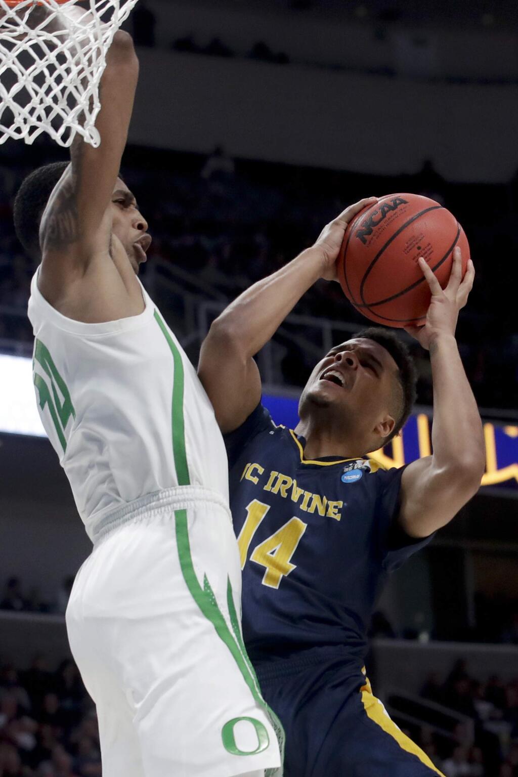 UC Irvine guard Evan Leonard, right, looks to shoot past Oregon forward Kenny Wooten during the second half of a second-round game in the NCAA men's college basketball tournament Sunday, March 24, 2019, in San Jose, Calif. (AP Photo/Jeff Chiu)