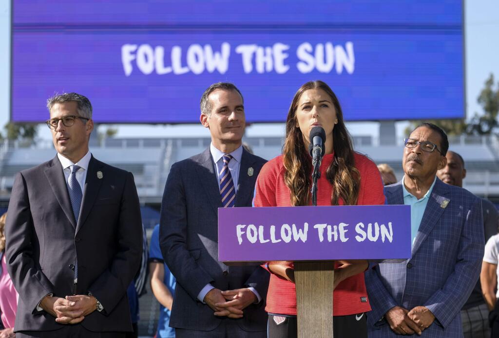 U.S. women's soccer team Alex Morgan speaks during a press conference as Los Angeles Mayor Eric Garcetti, second left, made an announcement for the city to host the Olympic Games and Paralympic Games 2028, at Stubhub Center in Carson, outside of Los Angeles, Calif., Monday, July 31, 2017. (AP Photo/Ringo H.W. Chiu)