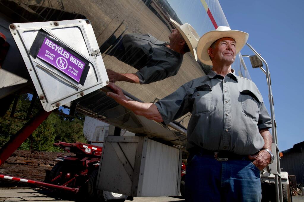 Richard Rued stands next to a water tanker truck that he uses to transport recycled water from the city of Healdsburg to irrigate his grapes at Rued Winery, on Thursday, Aug. 21, 2014. (BETH SCHLANKER / The Press Democrat)