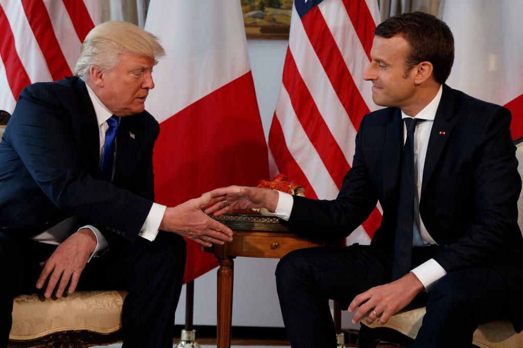 FILE - In this May 25, 2017 file photo, US President Donald Trump, shakes hands with French President Emmanuel Macron, right, during a meeting at the U.S. Embassy in Brussels. Macron arrives Monday April 23, 2018 in Washington for the first state visit of Trump's presidency. The two men have an unlikely friendship, despite strong differences on areas such as climate change. (AP Photo/Evan Vucci, File)