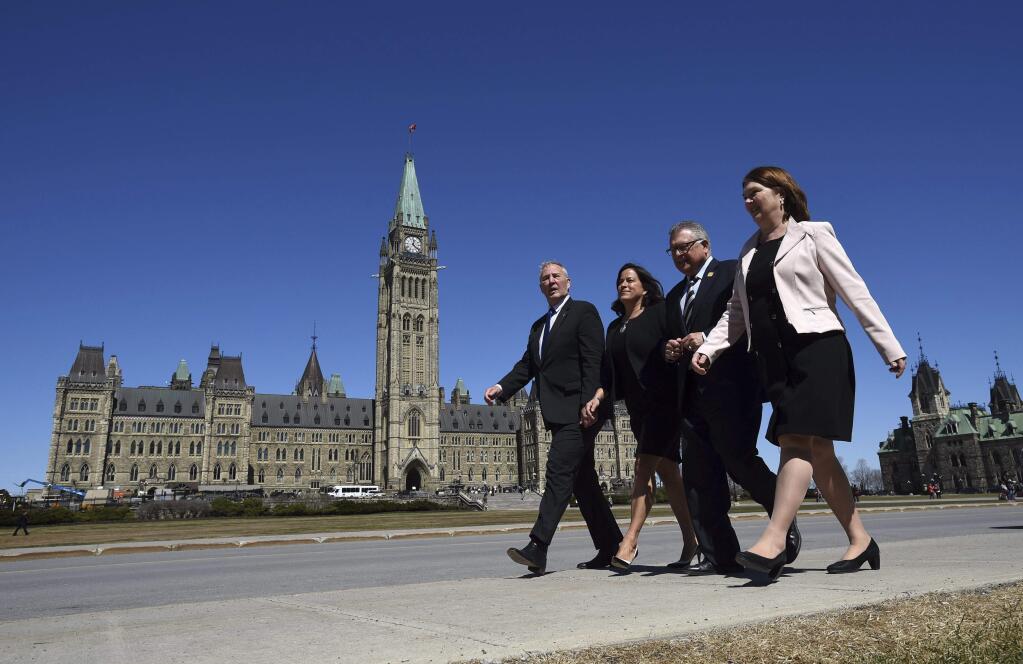 From left to right, Canada's Parliamentary Secretary Bill Blair, Justice Minister and Attorney General of Canada Jody Wilson-Raybould, Public Safety and Emergency Preparedness Minister Ralph Goodale and Health Minister Jane Philpott make their way to the National Press Theatre in Ottawa, Ontario on Thursday, April 13, 2017. Canadian Prime Minister Justin Trudeau's government has introduced legislation to let adults to possess 30 grams of marijuana in public. (Sean Kilpatrick/The Canadian Press via AP)