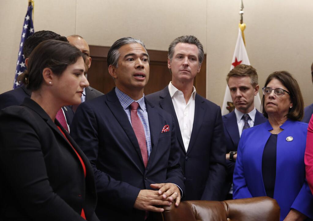 Assemblyman Rob Bonta, D-Oakland, second from left, flanked by California Gov. Gavin Newsom, center, and other lawmakers, discusses his measure that will ban the use of for-profit, private detention facilities, Friday, Oct. 11, 2019,. at the Capitol in Sacramento, Calif. Bonta's measure, AB32, which includes those detentions facilities the federal government uses for immigrants awaiting deportation hearings, was one of more than a measures signed by Newsom Friday. (AP Photo/Rich Pedroncelli)
