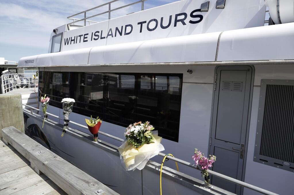Bouquets of flowers sit on one of the two tour boats that went to White Island on Dec. 9 in Whakatane, New Zealand, Wednesday, Dec. 11, 2019. Survivors of a powerful volcanic eruption in New Zealand on Monday ran into the sea to escape the scalding steam and ash and emerged covered in burns, say those who first helped them. (AP Photo/Mark Baker)