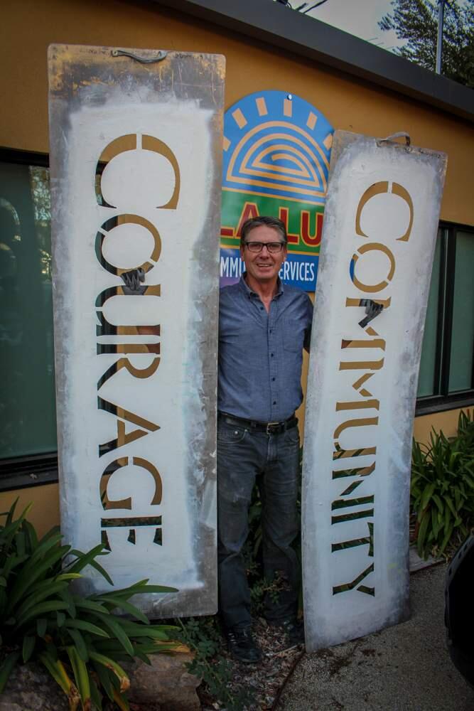 Peter Hassen, creator of 'Values Without Borders,' displays two of his die-cut templates. (photo by Ann Trinka)