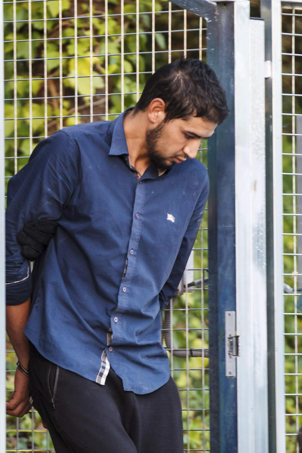 Un-named alleged member of a terror cell accused of killing 15 people in attacks in Barcelona leaves a Civil Guard base on the outskirts of Madrid before appearing in court in Madrid, Spain, Tuesday Aug. 22, 2017. Four men were arrested last week for their alleged involvement in the planning or execution of attacks in Barcelona on Thursday and the northeastern resort town of Cambrils early Friday.(AP Photo)