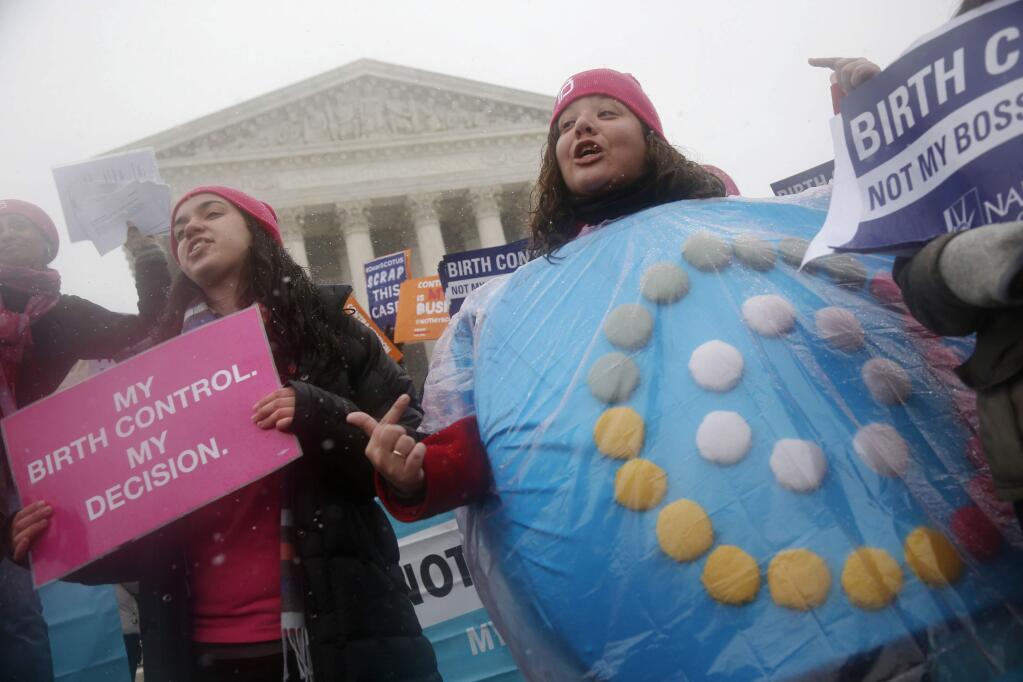 FILE - In this March 25, 2015 file photo, Margot Riphagen of New Orleans, La., wears a birth control pills costume during a protest in front of the U.S. Supreme Court in Washington. A U.S. judge will hear arguments Friday, Jan. 11, 2019, over California's attempt to block new rules by the Trump administration that would allow more employers to opt out of providing no-cost birth control to women. The new rules are set to go into effect on Monday, Jan. 14, 2019. (AP Photo/Charles Dharapak, File)