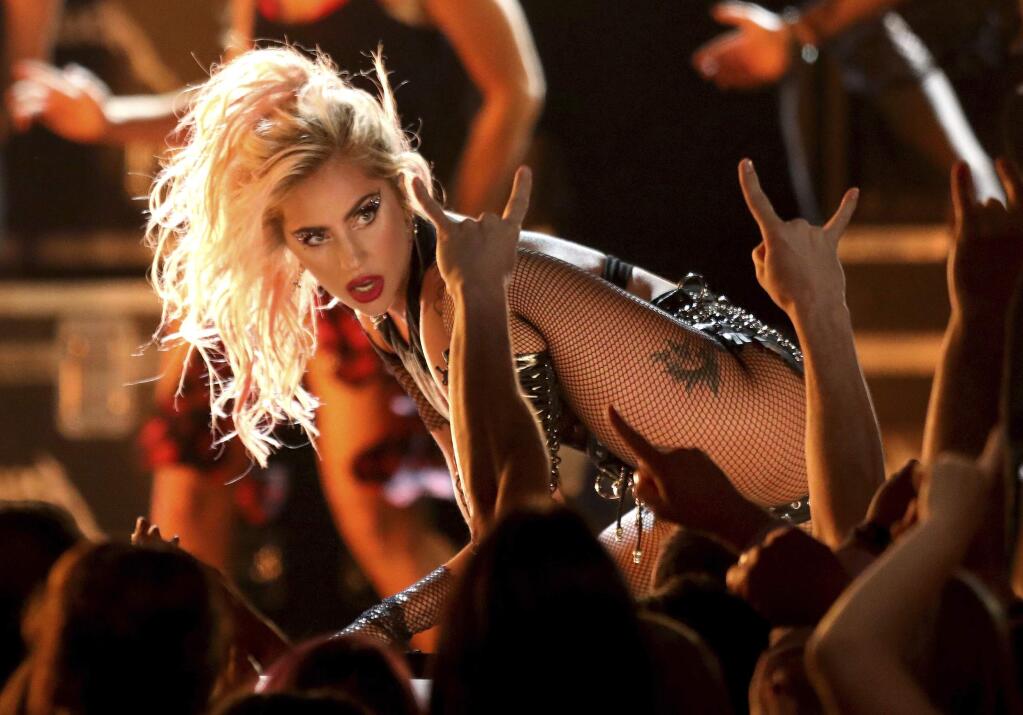 FILE - In this Feb. 12, 2017 file photo, Lady Gaga performs 'Moth Into Flame' at the 59th annual Grammy Awards in Los Angeles. Whether it's at a bar or baseball park, Lady Gaga said she's going to give every performance her all. The pop star will launch a summer tour with stops at arenas and stadiums across the globe, and she's also returning to the Dive Bar Tour with Bud Light to perform a show in Las Vegas on July 13. (Photo by Matt Sayles/Invision/AP, File)