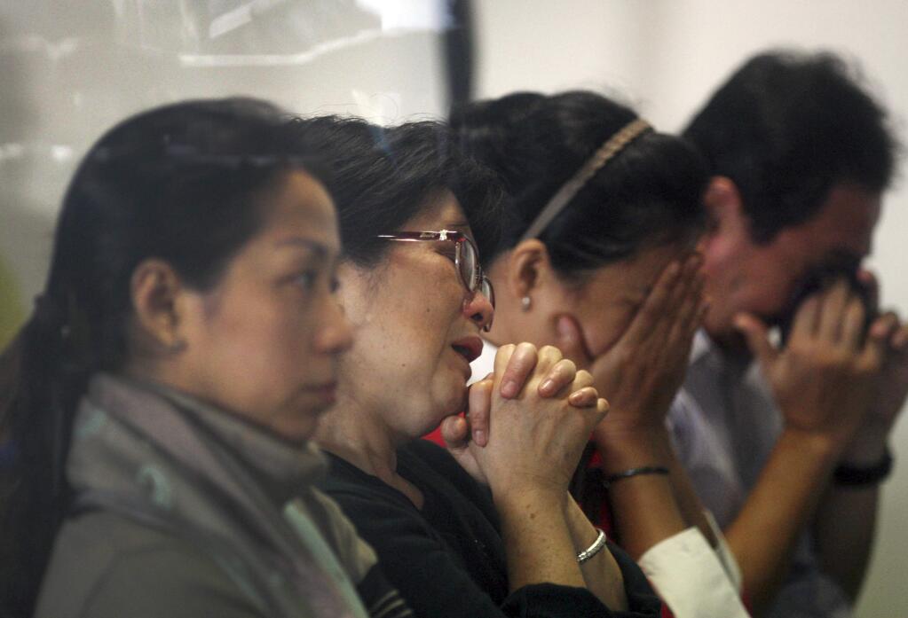 Relatives and next-of-kin of passengers on the AirAsia flight QZ8501 wait for the latest news on the search of the missing jetliner at Juanda International Airport in Surabaya, East Java, Indonesia, Monday, Dec. 29, 2014. Search planes and ships from several countries on Monday were scouring Indonesian waters over which the AirAsia jet disappeared, more than a day into the region's latest aviation mystery. The Flight 8501 vanished Sunday in airspace thick with storm clouds on its way from Surabaya, Indonesia, to Singapore. (AP Photo/Trisnadi Marjan)