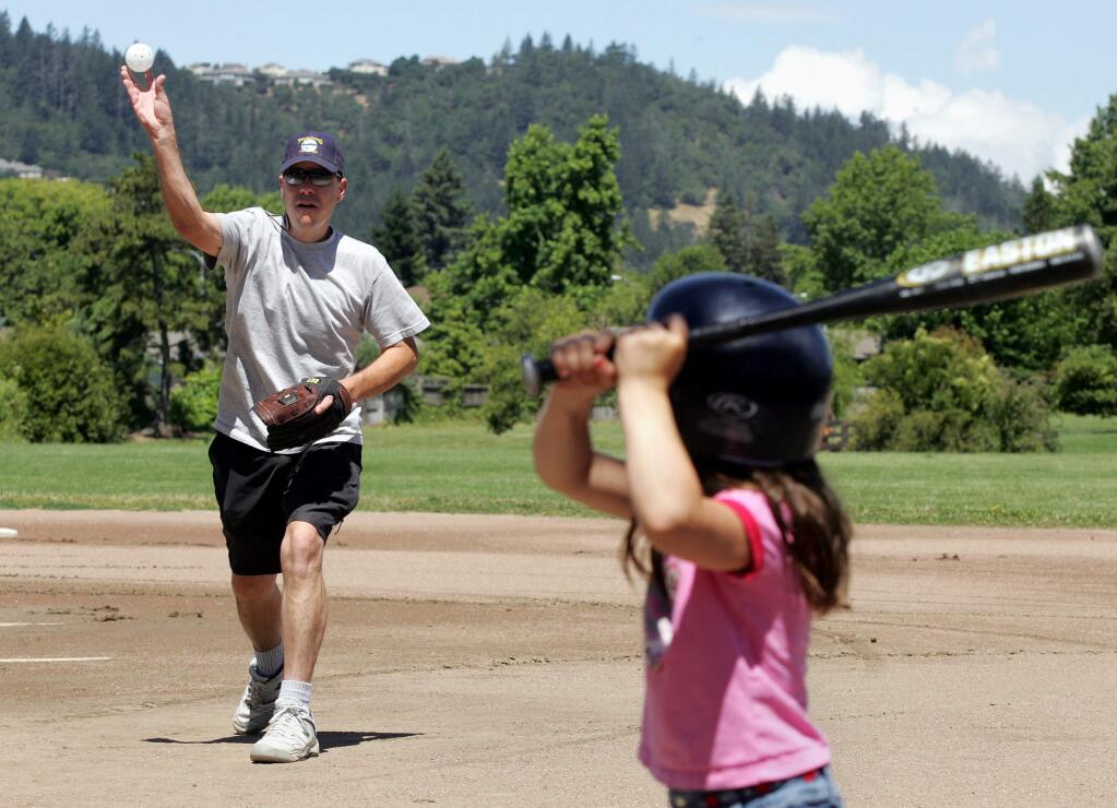 6/20/2005: B1: Andy Chew takes advantage of the sunny Father's Day with his 7-year-old daughter, Hannah Chew, at Rincon Valley Community Park on Sunday.PC: Photo by Christopher Chung/ The Press Democrat Andy Chew takes advantage of the sunny Father's Day morning by pitching to his 7-year-old daughter Hannah Chew at Rincon Valley Community Park on Sunday morning, June 19, 2005.
