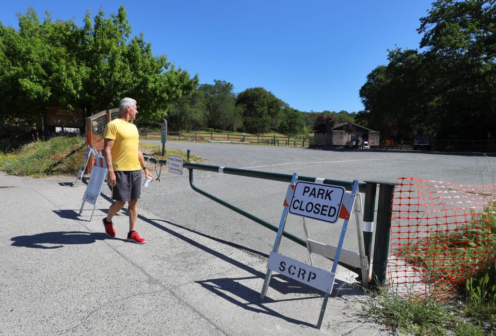 David Desisto looks into the closed Foothill Regional Park as he passes by on his walk, in Windsor on Tuesday, April 28, 2020. (Christopher Chung/ The Press Democrat)