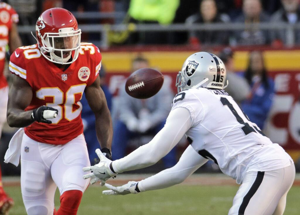 Oakland Raiders wide receiver Michael Crabtree (15) attempts to catch the ball after it deflected off the arm of Kansas City Chiefs defensive back Steven Terrell (30) during the second half of an NFL football game in Kansas City, Mo., Sunday, Dec. 10, 2017. Crabtree did not catch the ball. (AP Photo/Charlie Riedel)