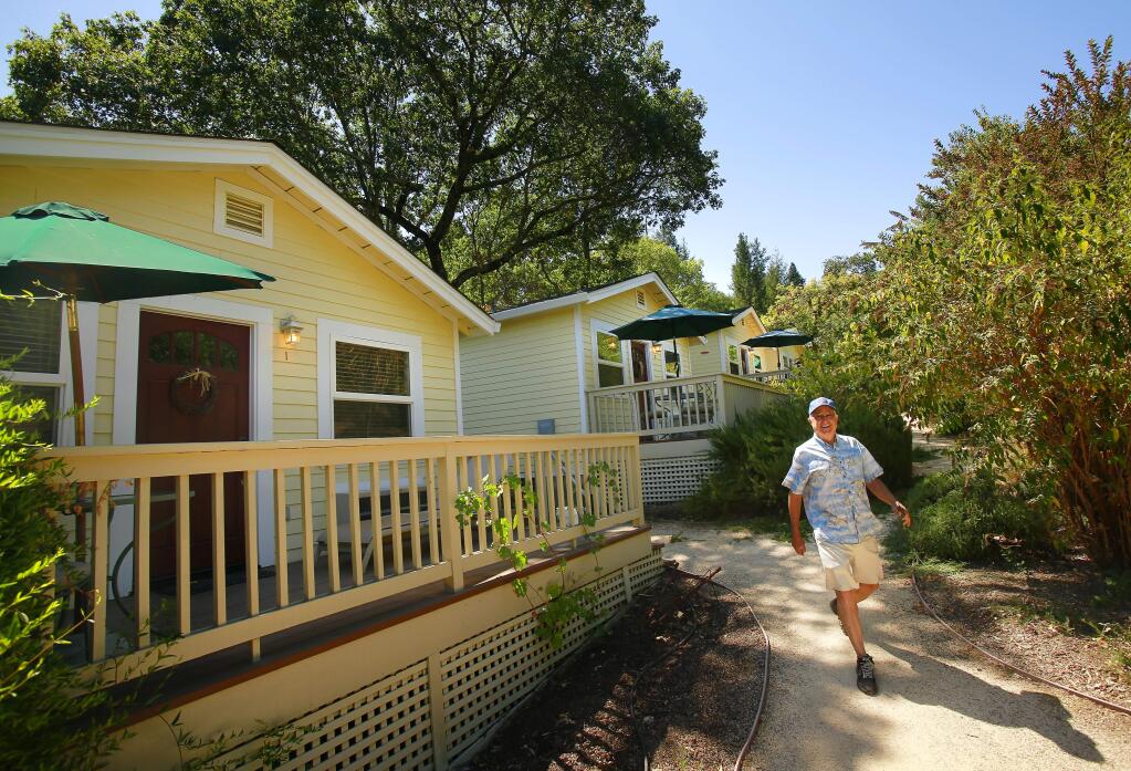 The owner of Aurora Park Cottages, Joe Hensley, walks by the trail around his six cottages for sale for a cost of $1.55 million in Calistoga on Friday, Aug. 8, 2014. (Conner Jay/The Press Democrat)