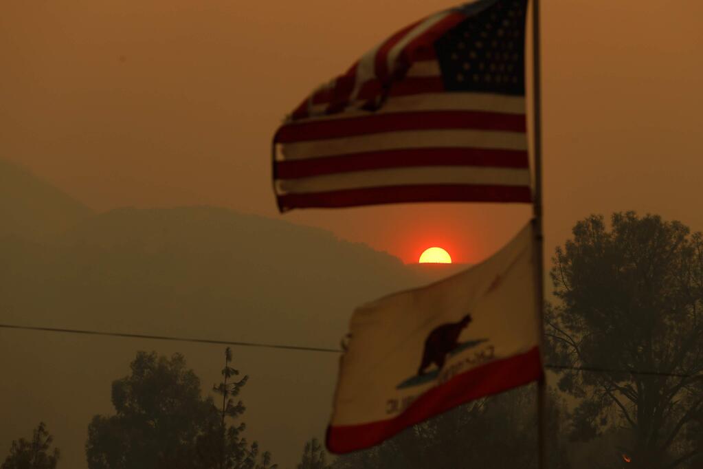 Smoke from the Ranch fire obscures the sun as it sets behind the hills above the community of Spring Valley near Clearlake Oaks, California, on Saturday, Aug. 4, 2018. (ALVIN JORNADA/ PD)