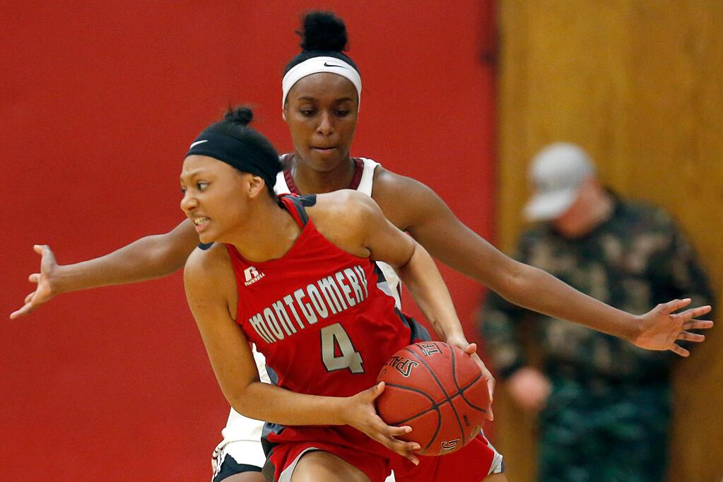 Montgomery's Trinity Hawkins (4), left, looks for a way around Cardinal Newman's Arie Searcy (5) during the first half of a girls varsity basketball game between Montgomery and Cardinal Newman high schools, in Santa Rosa, California, on Wednesday, January 31, 2018. (Alvin Jornada / The Press Democrat)