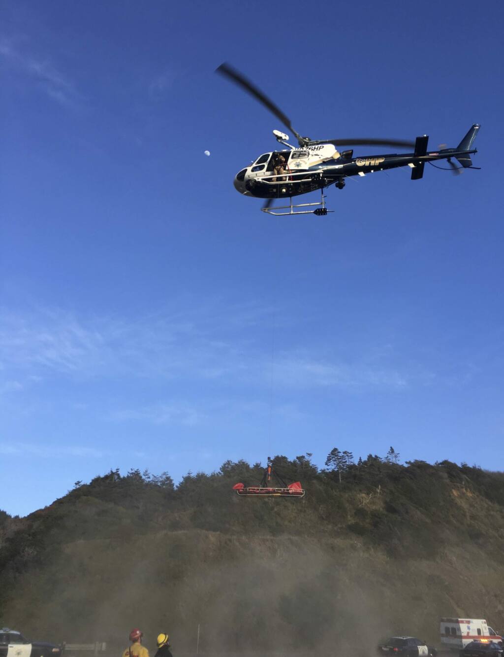 This Tuesday, March 27, 2018, photo provided by the California Highway Patrol shows a helicopter hovering over the scene where a vehicle plunged off a cliff in Northern California near Mendocino, Calif. The California Highway Patrol identified the adult victims Wednesday as Jennifer Hart and Sarah Hart, who died along with a few other children. (California Highway Patrol via AP)