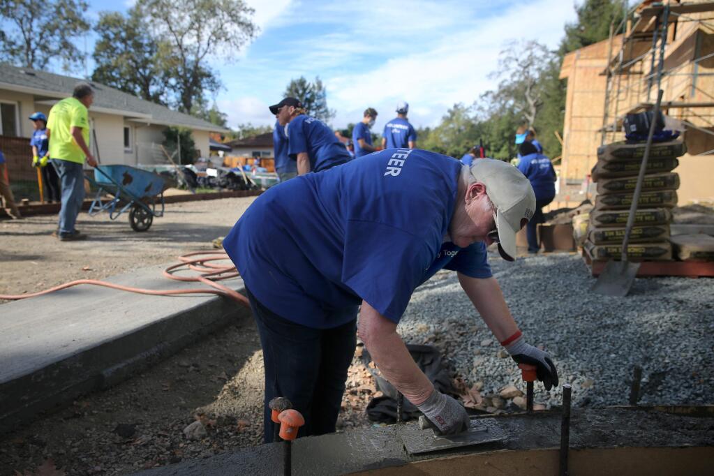 Linda Maule smooths out cement as she joins with volunteers working on three new single family homes on West Steele Lane as part of Habitat for Humanity's Raise the Roof campaign on Sunday, October 28, 2018 in Santa Rosa, California . (BETH SCHLANKER/The Press Democrat)