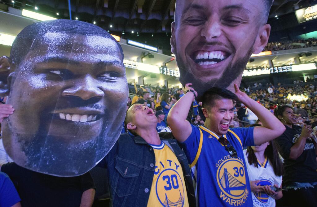 Fans react while watching television coverage of the Golden State Warriors playing the Cleveland Cavaliers in Game 4 of the NBA Finals, at Oracle Arena in Oakland, Calif., Friday, June 8, 2018. (AP Photo/Josh Edelson)
