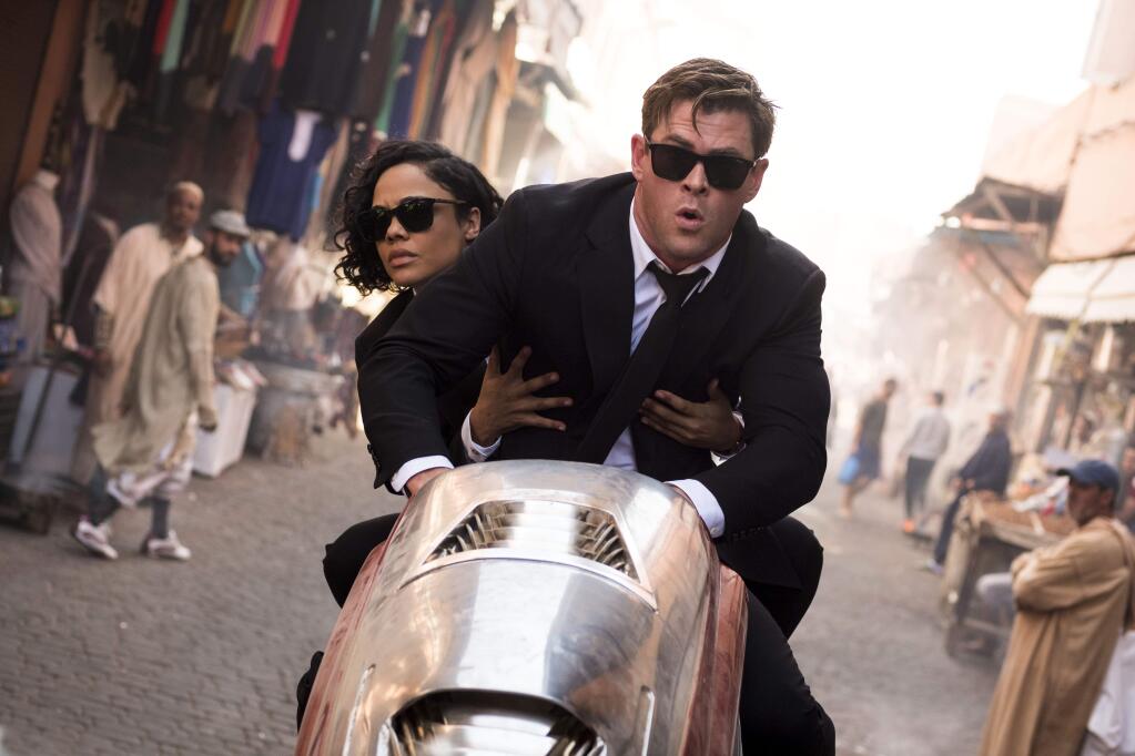 This image released by Sony Pictures shows Chris Hemsworth, foreground, and Tessa Thompson in a scene from Columbia Pictures' 'Men in Black: International.' (Giles Keyte/Sony/Columbia Pictures via AP)