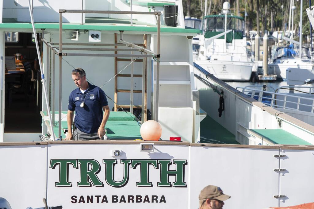 FBI agents search the Truth dive boat, a sister vessel to the Conception, as authorities issue a search warrant for the Truth Aquatics' offices on the Santa Barbara Harbor in Santa Barbara, Calif., Sunday, Sept. 8, 2019. The office was ringed in red 'crime scene' tape as more than a dozen agents took photos and carried out boxes. Thirty-four people died when the Conception burned and sank before dawn on Sept. 2. They were sleeping in a cramped bunkroom below the main deck and their escape routes were blocked by fire. (AP Photo/Christian Monterrosa)